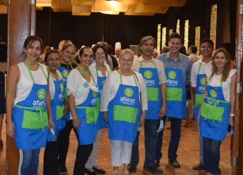 Grupo de voluntarios con delantales de la Fundación AFANIC en una edición del evento